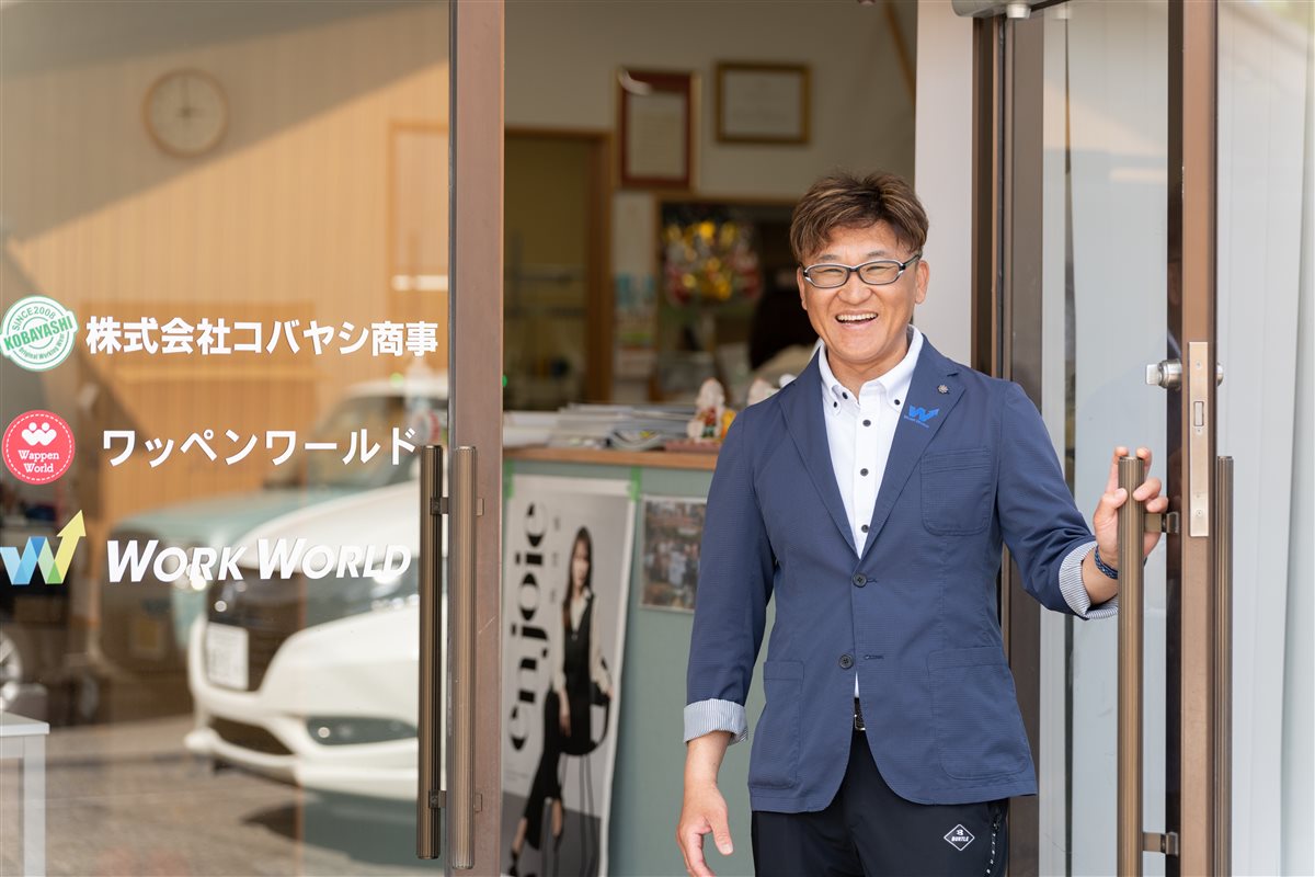 株式会社コバヤシ商事の入口に立つ代表