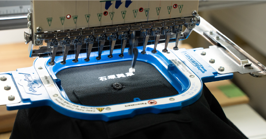 刺繍機で衣類に文字を刺繍する様子